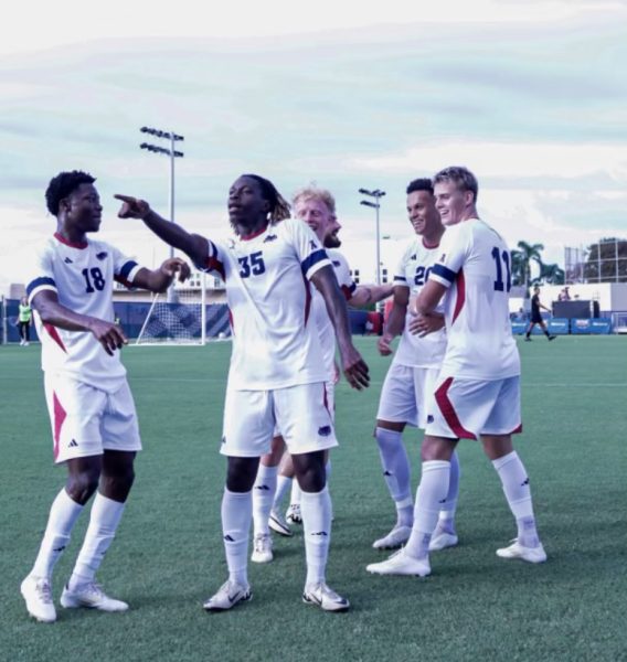 Senior forward Mamadou Diarra celebrates with his teammates after scoring his third goal to make it a hat trick in the first half.