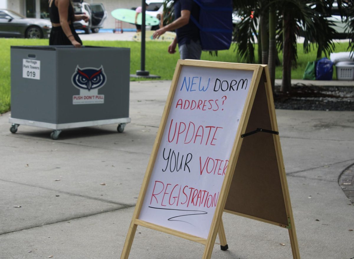 A sign in front of the People Power for Florida campaign table to inform students to update their voting registration with their new dorm.