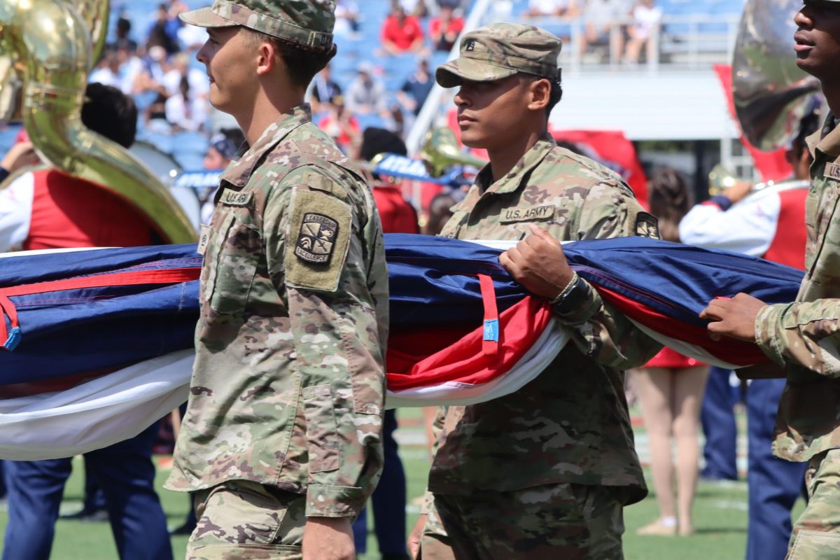 Military Personnel walk in a marching line to solute the flag in FAU versus Army game holding a flag on Sept. 7, 2024. 