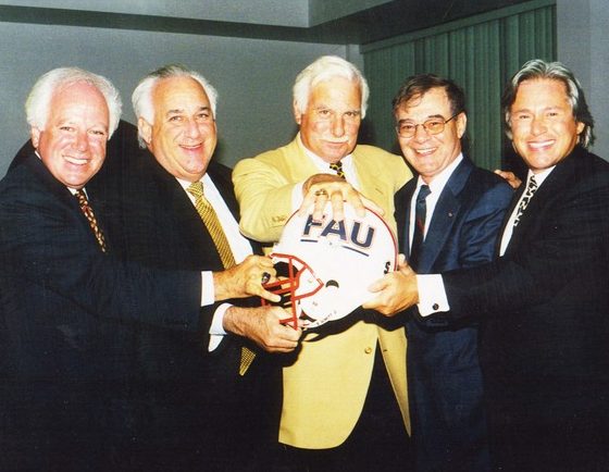 Dr. Catanese, left, and coach Howard Schnellenberger, center, pose with the helmet of FAU's football team