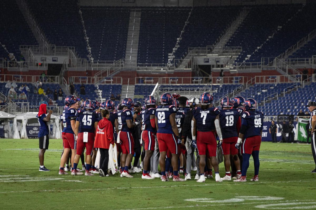 FAU Football in a huddle during a timeout in their match against the University of North Texas on Oct. 13, 2024