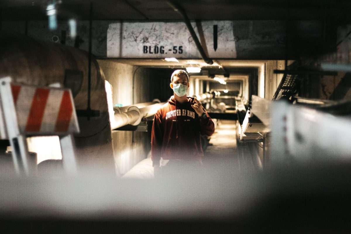 An unmanned individual wearing a face mask in the utility tunnels beneath the Physical Science Building.