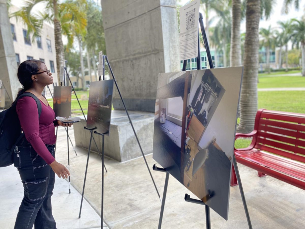 A student observes student Tylor Randley's photograph, "A Place Of Paradise, A Place To Find Rest," at FAU's "Housing Insecurity in Paradise" gallery event on Oct. 16.