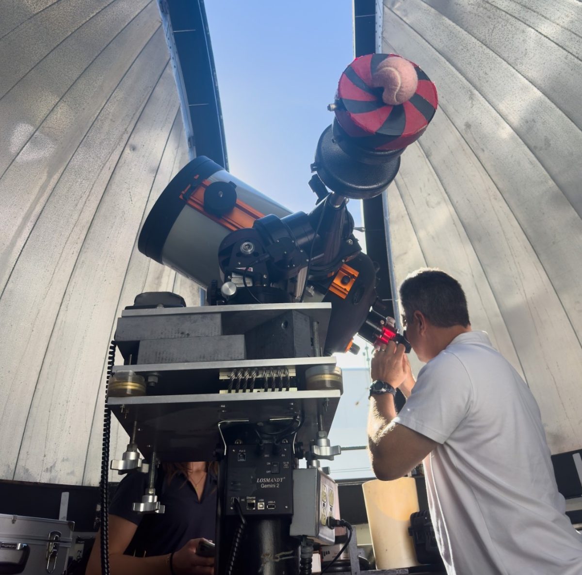 Eric Vandernoot looking through the Astronomical Observatory's telescope. 