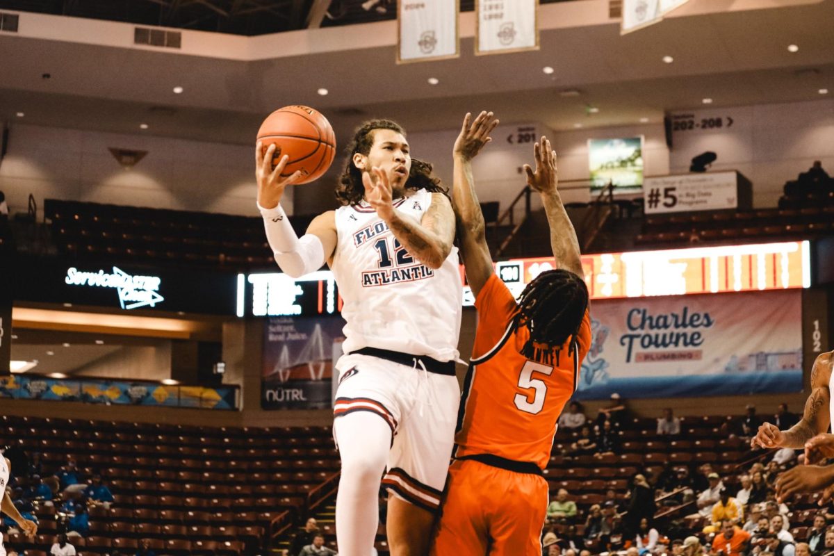 FAU forward Tre Carroll going for a layup against Oklahoma State's guard Khalil Brantley. 