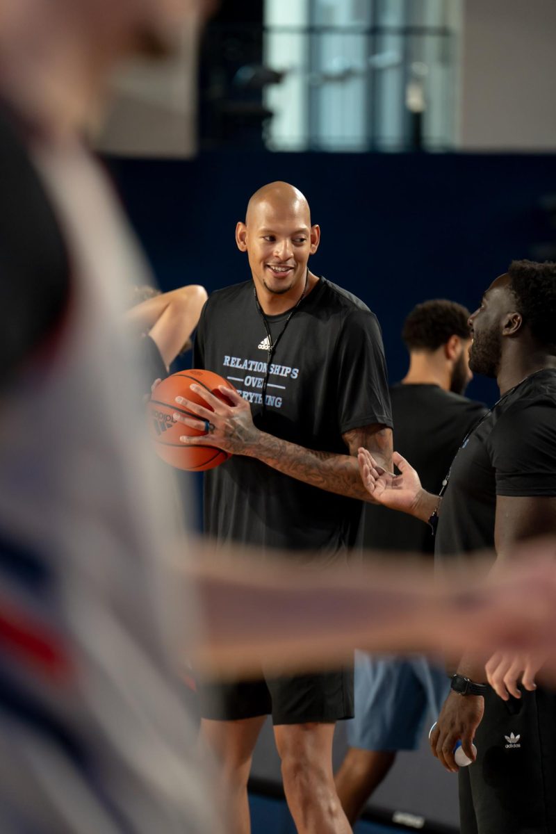 Assistant coach Isaiah Austin talking with special assistant to the head coach Obim Okeke at FAU's men's basketball practice. 