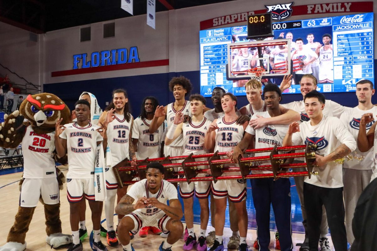 FAU’s men’s basketball team holding the third annual Boca Raton MegaBowl trophy. They bested Jacksonville University 85-63 on Dec. 10. 