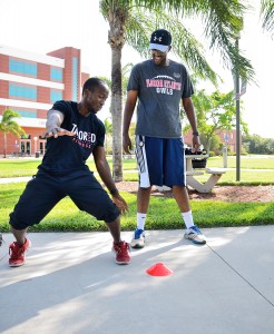 Bootcamp instructor Kamal Cudjoe shows a UP reporter how to properly perform an exercise. Photo by Ryan Murphy.