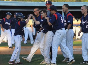 Pinch runner Geoff Jimenez (center) is congratulated by the bat boy (left) and his team after scoring the winning run during Saturday's game. The Owls beat FIU 6-5 by catcher Mike Spano's walk-off single in the bottom of the ninth, driving in Jimenez. Photo by Michelle Friswell.