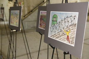 A child's picture depicting a person behind barbed wire stands among other art created by Palestinian children at the social sciences building.