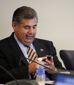 FAU Board of Trustees Chair Anthony Barbar checks his phone as Acting President Dennis Crudele presents the university’s 2013-2014 operating budget. Photo by Dylan Bouscher.